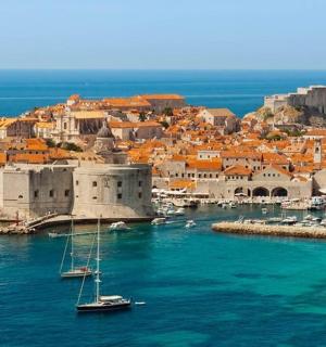 a group of boats in the water next to a city