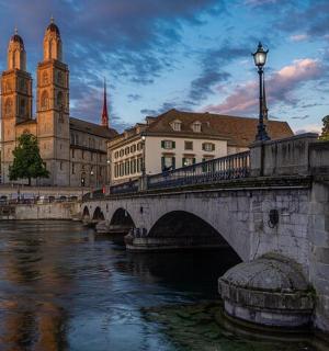 一座横跨河流的桥，位于一座有教堂的城市