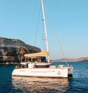 en vit båt i vattnet bredvid en klippa