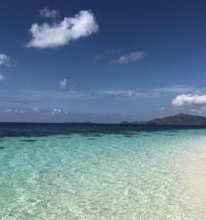 en strand med turkisblåt vand og mennesker på den
