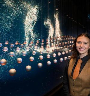 a woman standing in front of a wall of balls