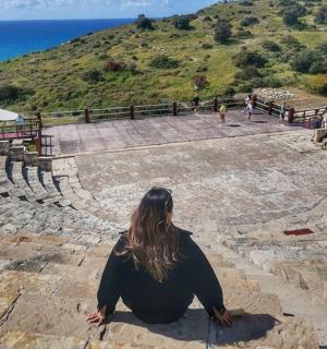 a woman sitting on the steps of an amphitheater