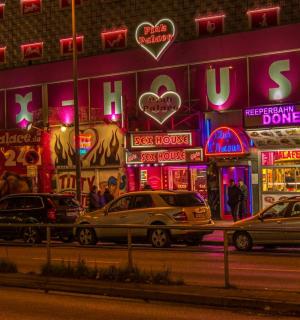a group of cars parked in front of a building with neon signs