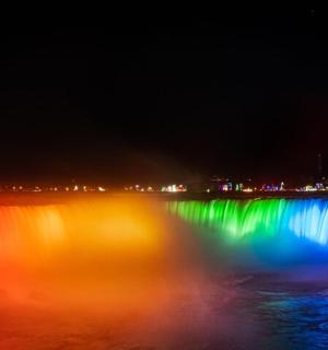 a reflection of a rainbow in the water at night