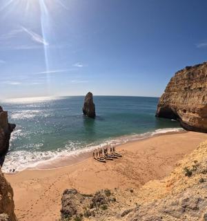 a group of people standing on a beach near the ocean