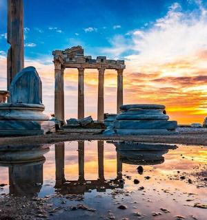 an ancient temple with a reflection in a puddle