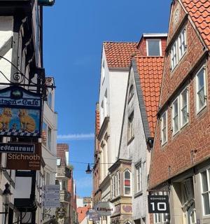 a narrow street with buildings and signs in a city