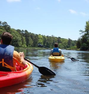 Dva muži kajakují na řece ve vodě