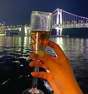 一个人在桥前拿着一杯酒