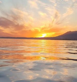 a sunset over a body of water with the sun setting