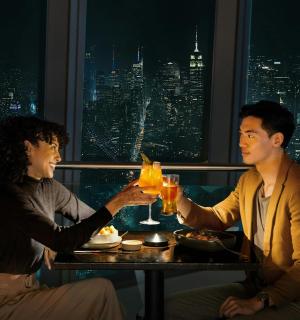 a man and woman sitting at a table with drinks