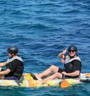 两个男人坐在水中的木筏上