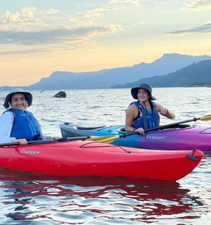 zwei Frauen sitzen in Kajaks auf dem Wasser