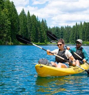 zwei Personen in einem gelben Kajak auf einem See