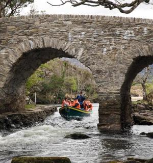 一群人在桥下的河上乘船