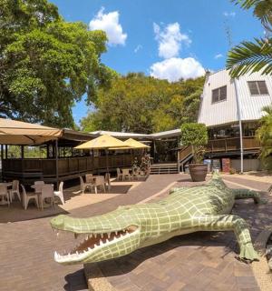 a statue of a crocodile laying on a brick patio