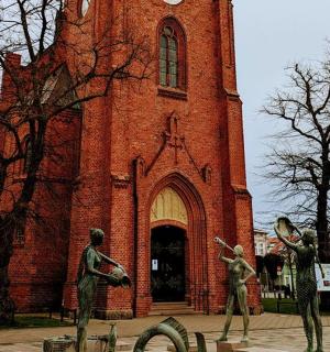 a large brick church with statues in front of it