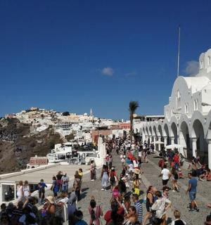dav lidí stojících kolem budovy s horou