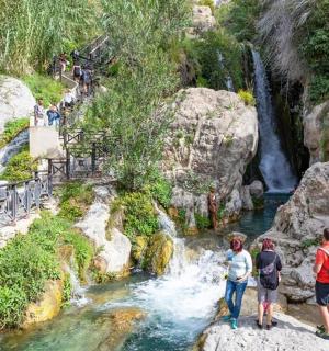 a group of people standing on rocks in a waterfall