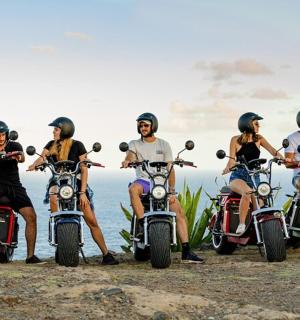 skupina lidí jedoucích na motorkách na pláži