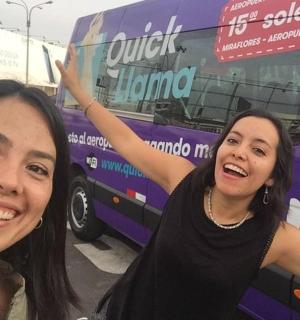 两名女子站在一辆紫色巴士前