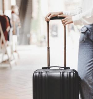 一名女子拿着一个黑色的手提箱