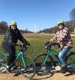 Dvě ženy pózují se svými koly v parku