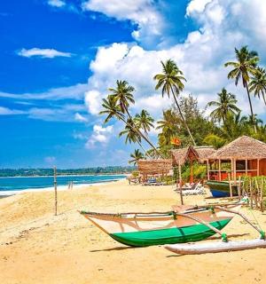 a beach with a green boat on the sand