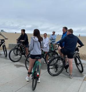 a group of people riding bikes on the beach