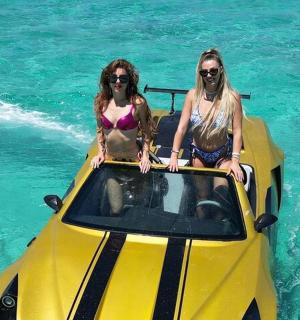 two women sitting on a yellow boat in the water