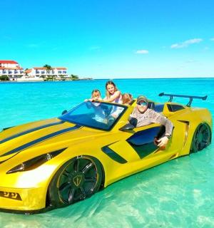 a group of people sitting in a yellow car in the ocean