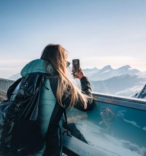 一位女士正在拍摄一座山