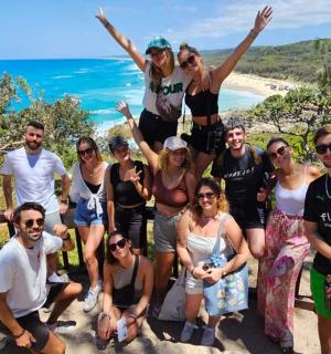 a group of people posing for a picture at the beach