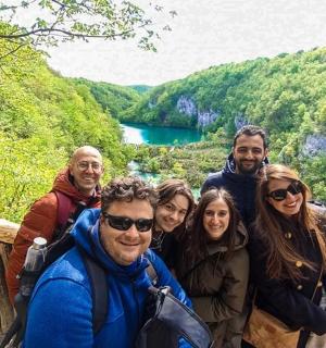 a group of people posing for a picture in front of a lake