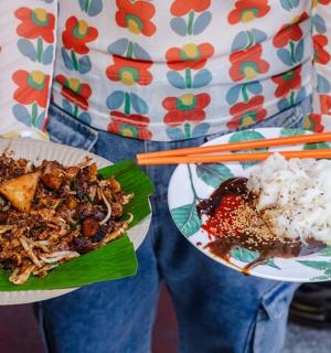 a person is holding two plates of food with chopsticks