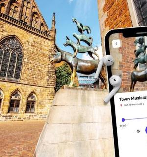 an iphone taking a picture of a statue in front of a building