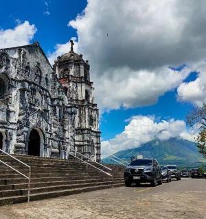 一座老建筑，前面停着汽车
