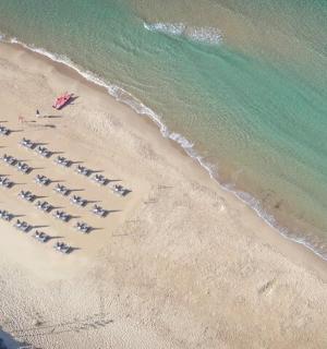 an overhead view of a beach with a line of boats
