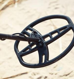 沙子中黑色金属物体的特写