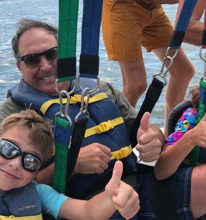 一名男子和两个孩子在船上竖起大拇指