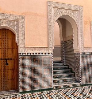 a building with two arches and a staircase between two doors