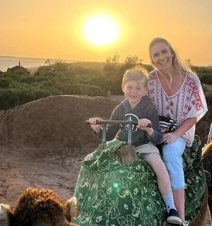 一名妇女和一名儿童骑在袋子上