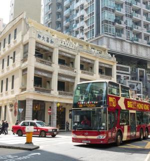 a red double decker bus driving down a city street