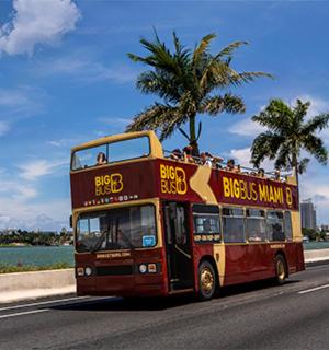 a red double decker bus driving down a street