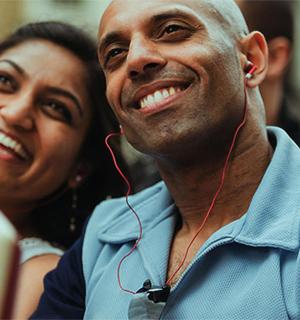 a man with ear buds in his ears with a woman