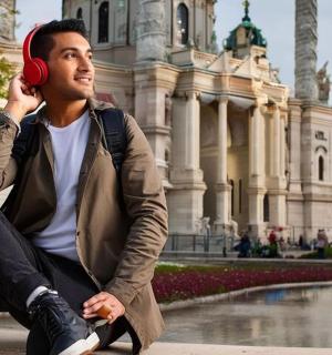 a man sitting on the ground talking on a cell phone