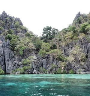 ein Boot im Wasser neben einem Berg