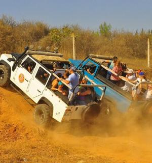 一群人乘坐吉普车在土路上行驶