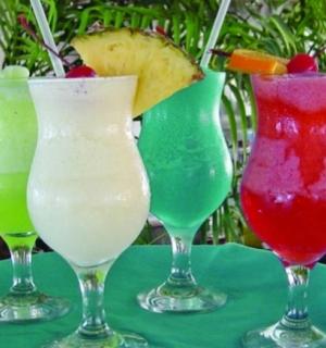 Skupina čtyř různobarevných nápojů na stole