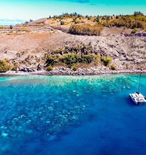 a boat in the water next to a small island